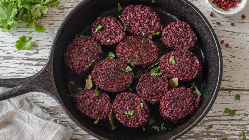 Rodajas de morcilla vegana de arroz y remolacha en una sartén