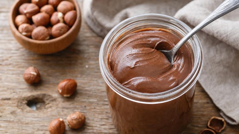 Tarro de crema de cacao y avellanas vegana con una cuchara, imagen de la receta de Nutella vegana